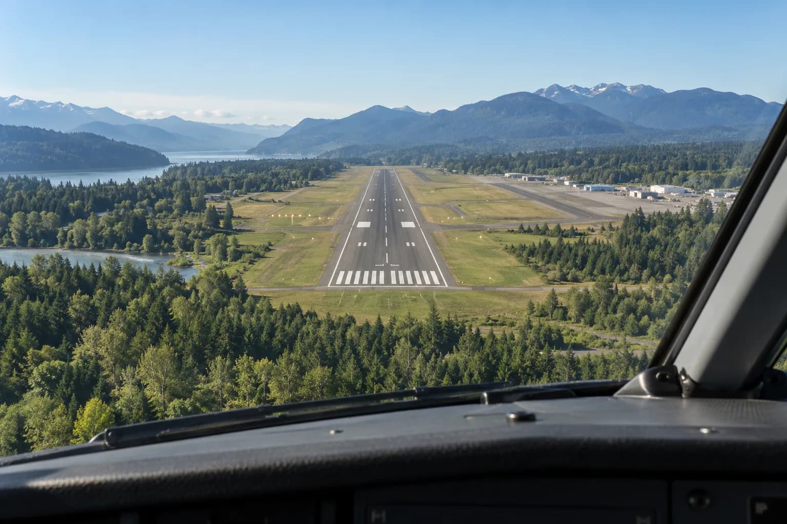 Illustrative view from a cockpit toward a runway in a green valley.